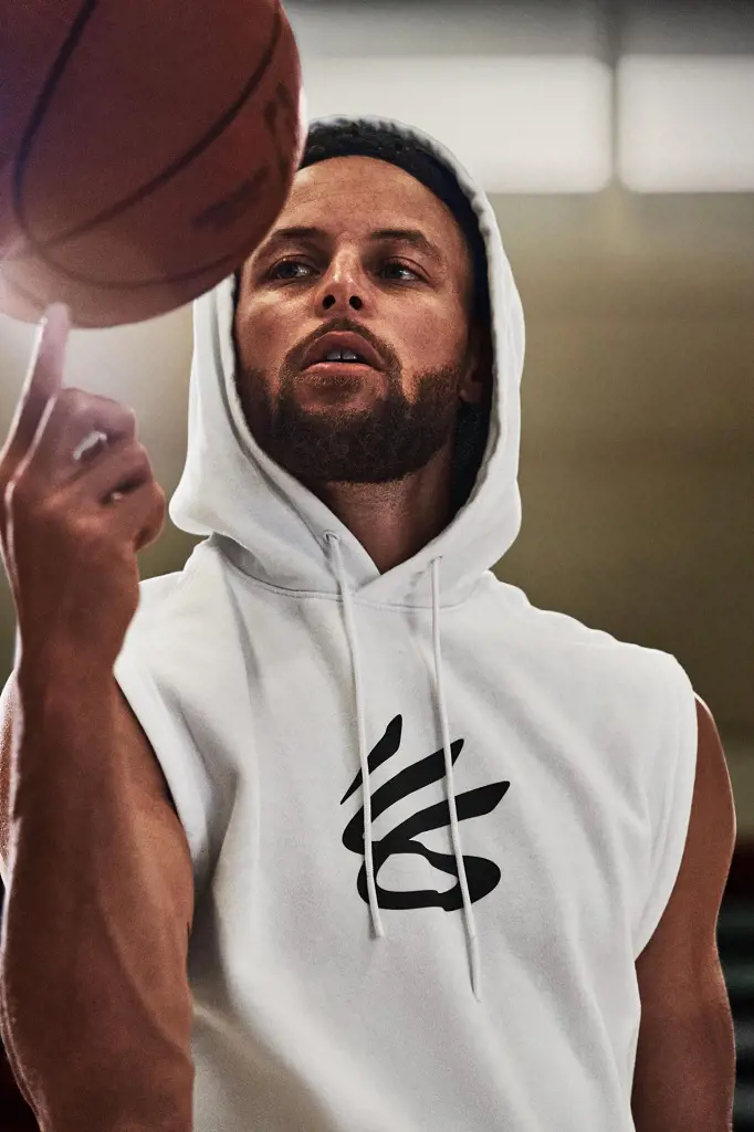 Image: Stephen Curry in a white hoodie with basketball